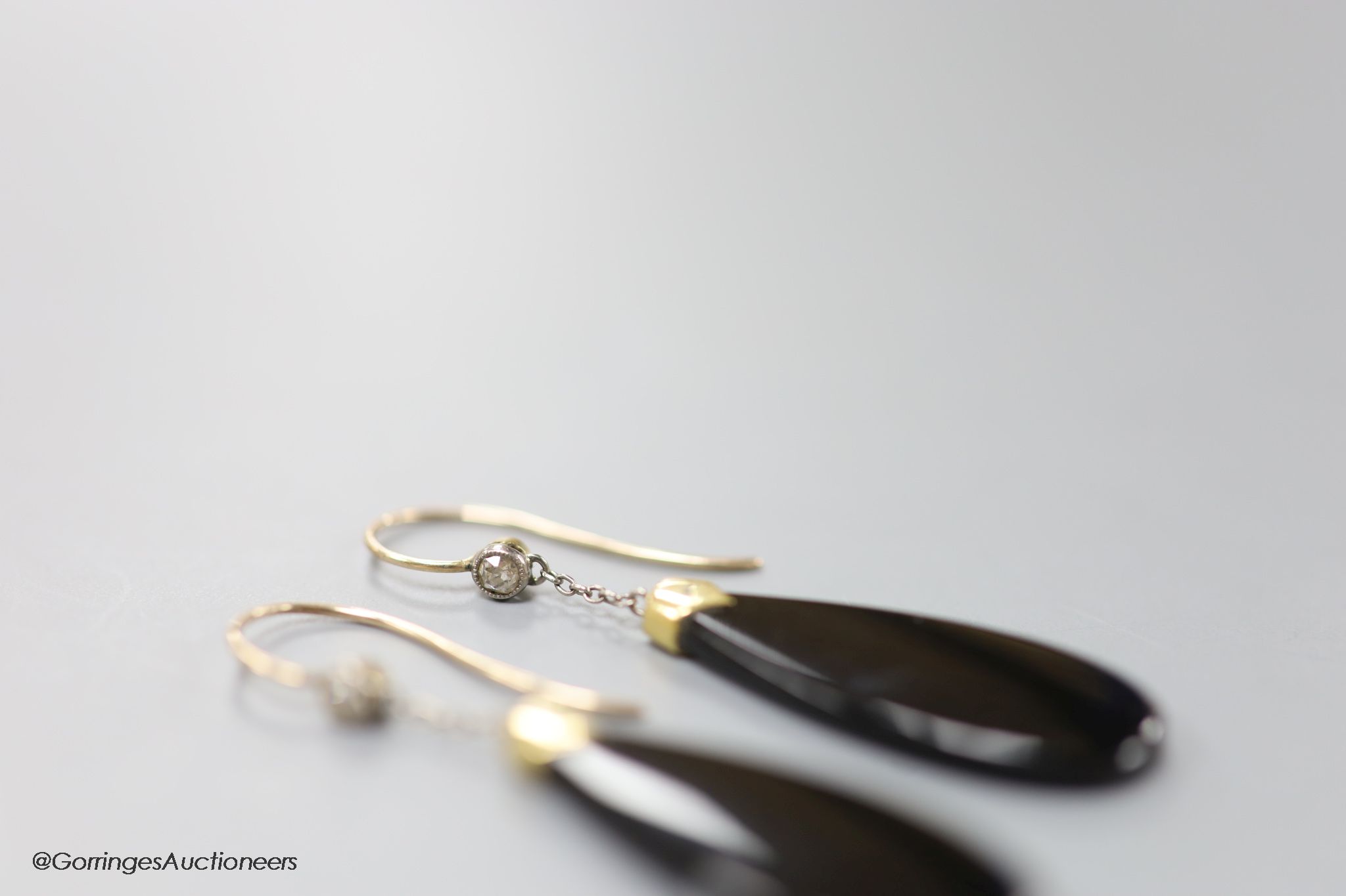 A pair of early 20th century yellow metal mounted black onyx and diamond set pear shaped drop earrings, 40mm, gross 4.6 grams.